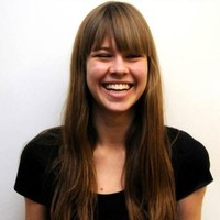 A color photo of a woman smiling for a photo